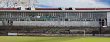 Vista exterior del Polideportivo Olaranbe con gradas y campo de césped