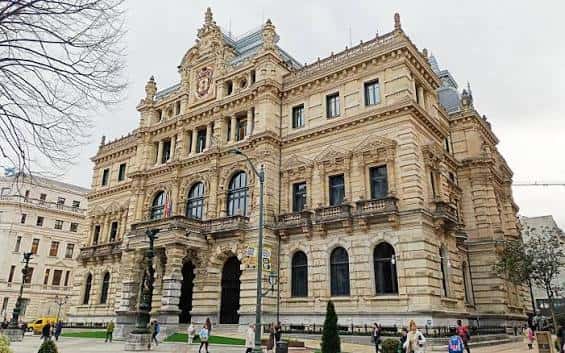 Ángulo lateral del Palacio Foral de Bilbao con peatones y detalles arquitectónicos en primer plano