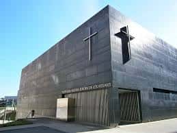 Fachada exterior moderna de la Parroquia de Nuestra Señora de los Rosales con cruz y detalles arquitectónicos