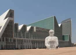 Vista exterior del Palacio de Congresos de Zaragoza con su distintiva arquitectura moderna y una escultura en primer plano