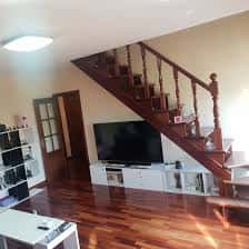 Interior de un dúplex en Calzada das Gándaras con escalera de madera y salón amplio