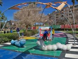 Zona de juegos infantiles con estructuras modernas y colores vivos en el parque