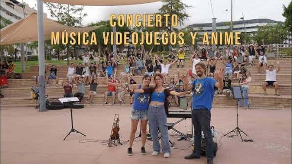 Concierto al aire libre con público en gradas y artistas en el escenario del parque