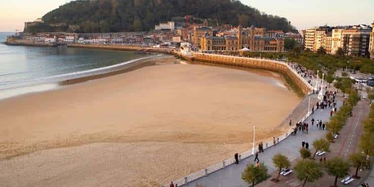 Playa de La Concha al atardecer con paseantes