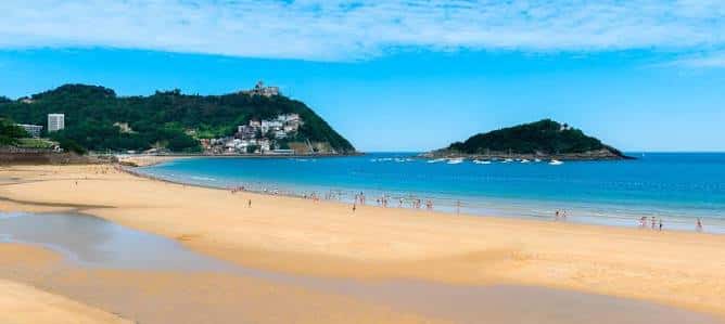 Arena dorada y mar turquesa de La Concha con la isla de Santa Clara