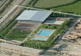Vista aérea del complejo deportivo mostrando las pistas de pádel y la piscina