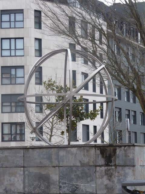 Detalle del reloj solar metálico en la plaza