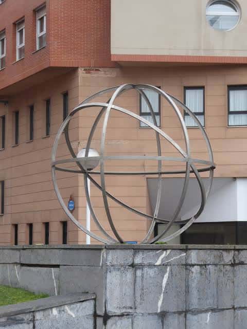 Vista del reloj solar con edificios de fondo