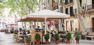 Terraza de cafetería en Passeig del Born con clientes disfrutando del ambiente