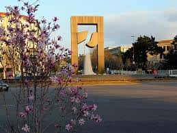 Escultura dorada en la Alameda de A Salgueira con flores de primavera al atardecer