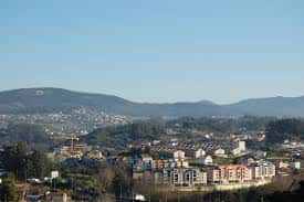 Vista panorámica del barrio de A Salgueira con edificios residenciales y montañas de fondo