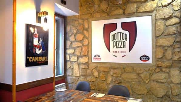 Interior del restaurante con decoración de piedra y mesas de madera