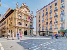 Vista general de la Plaza de Santa Ana con edificios históricos y personas caminando