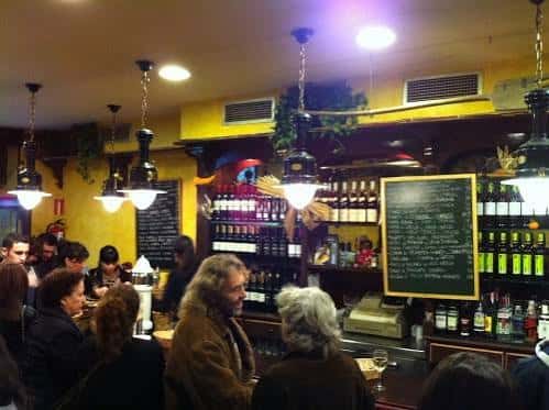 Interior acogedor de Borda Berri con barra, botellero y comensales disfrutando