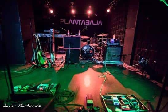 Escenario del club Planta Baja con instrumentos y luces verdes