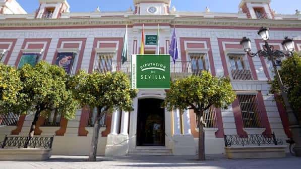 Entrada monumental de la Diputación de Sevilla con fachada neoclásica y letrero verde