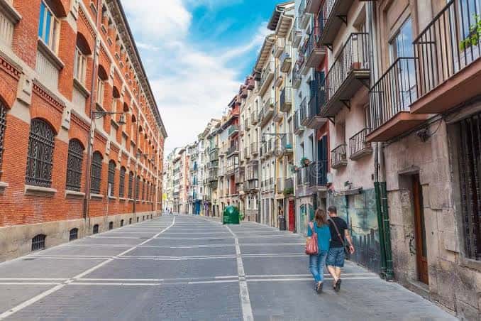 Calle Nueva de Pamplona con pareja caminando bajo el cielo azul