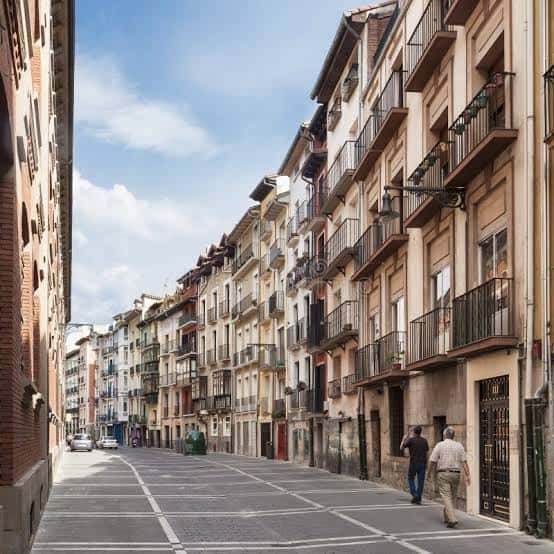 Calle Nueva de Pamplona con dos personas caminando y edificios históricos