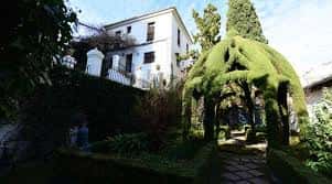 Jardín exterior con arboleda y camino pavimentado en Carmen de la Victoria