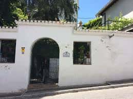 Entrada principal con arco y muro blanco del recinto de Carmen de la Victoria