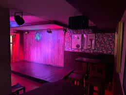 Escenario principal de la taberna con iluminación de colores