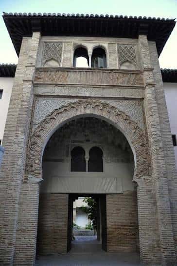 Fachada principal del Corral del Carbón con arco de herradura y decoración mudéjar