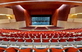 Vista general del interior del auditorio con butacas rojas y balcones ornamentados