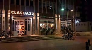 Fachada nocturna del local Clasijazz en Almería, con iluminación cálida y entrada accesible