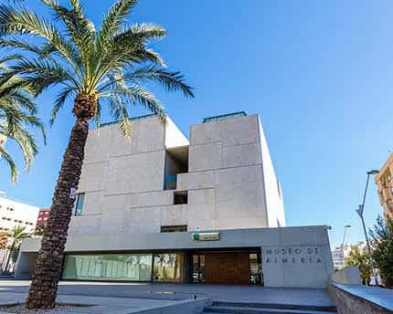 Vista exterior del Museo de Almería con palmeras y cielo azul