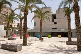 Plaza frontal del museo con palmeras y bancos de piedra
