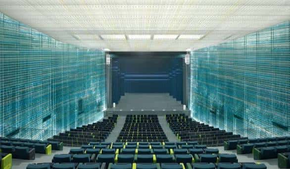 Interior del auditorio con butacas azules y paredes acústicas de vidrio