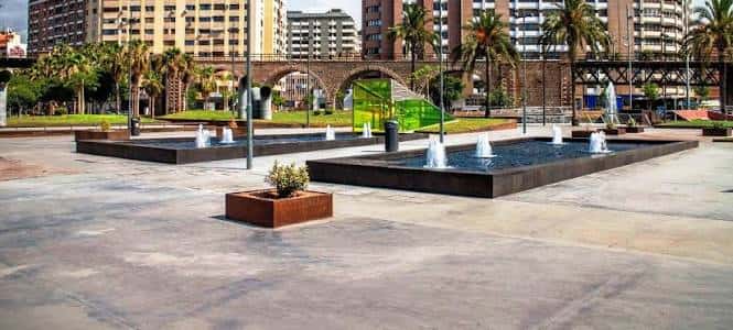 Vista panorámica del parque con fuentes y arcos de ladrillo
