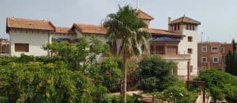 Vista exterior de la Casa del Cine con jardines y palmeras