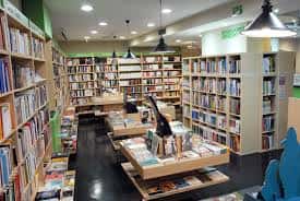 Vista general del interior de la librería Bibabuk con estanterías llenas de libros y lámparas colgantes