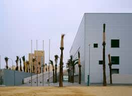 Fachada lateral del pabellón con banderas y diseño arquitectónico moderno