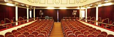 Interior del teatro con butacas rojas y cortinas