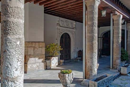 Claustro interior con columnas de piedra y detalles arquitectónicos medievales