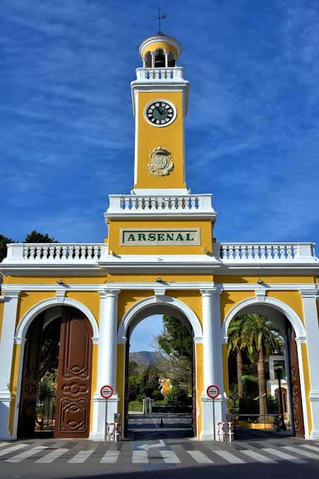 Vista frontal de la entrada principal del Arsenal de Cartagena con su característica torre amarilla y reloj