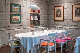 Sala privada con mesa redonda y sillas de colores, ideal para reuniones o cenas íntimas