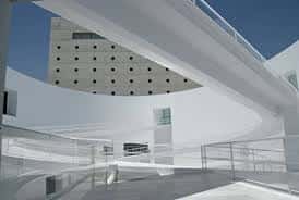 Detalle arquitectónico de la rampa curva y fachada del edificio bajo cielo azul