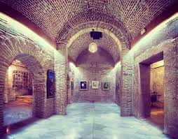 Vista interior de los Aljibes Árabes de Jairán con bóvedas de ladrillo y exposición de arte