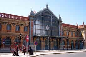 Fachada histórica de la estación de tren con arquitectura de hierro y ladrillo