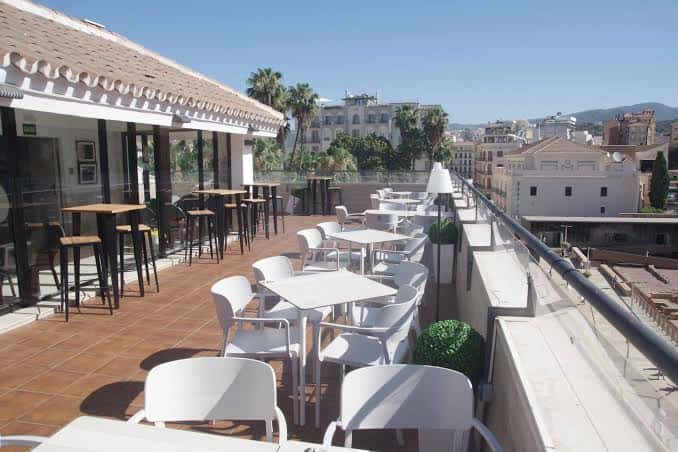 Terraza exterior del Área Socio-Cultural con mesas y vistas a la ciudad