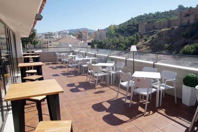 Vista panorámica de la terraza con mobiliario y paisaje urbano al fondo