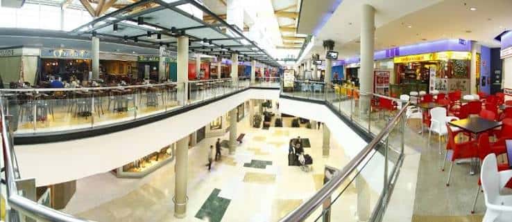 Interior del centro comercial mostrando zona de comida y pasarelas con clientes