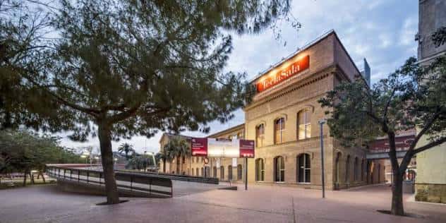 Vista exterior del Centro Cultural Metropolitano Tecla Sala al atardecer, con fachada de ladrillo y señalización iluminada