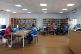 Usuarios leyendo en mesas dentro de la biblioteca