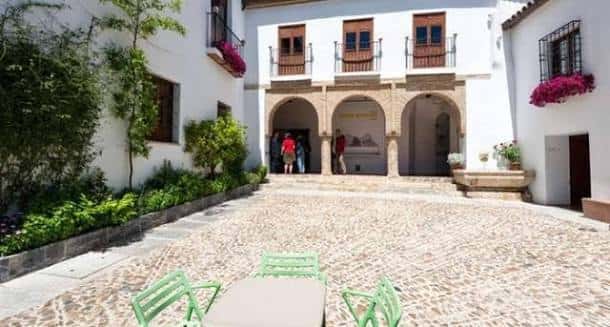 Vista general del patio principal con mesas y sillas verdes, ideal para eventos al aire libre