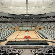 Interior del pabellón mostrando la cancha de baloncesto y estructura arquitectónica del techo
