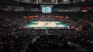 Evento deportivo en el Pabellón Olímpico con público lleno y cancha iluminada